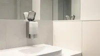Empty soap dispenser on a restroom wall